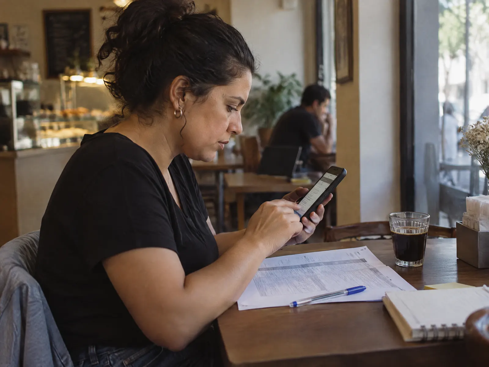 Candidata responde a um questionário no celular, com o cronograma na mesa